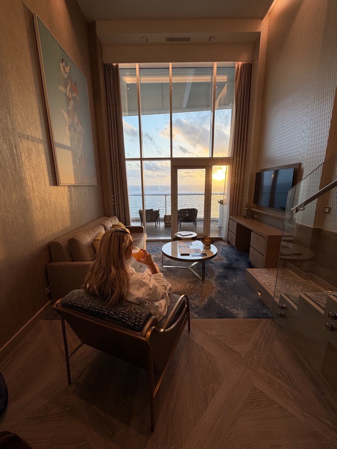 Two-story Royal Caribbean suite glowing in the sunset